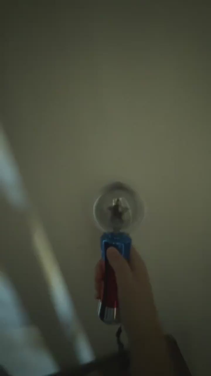 A parent demonstrates the colorful Mimsy Glow & Spin Sensory Wand.